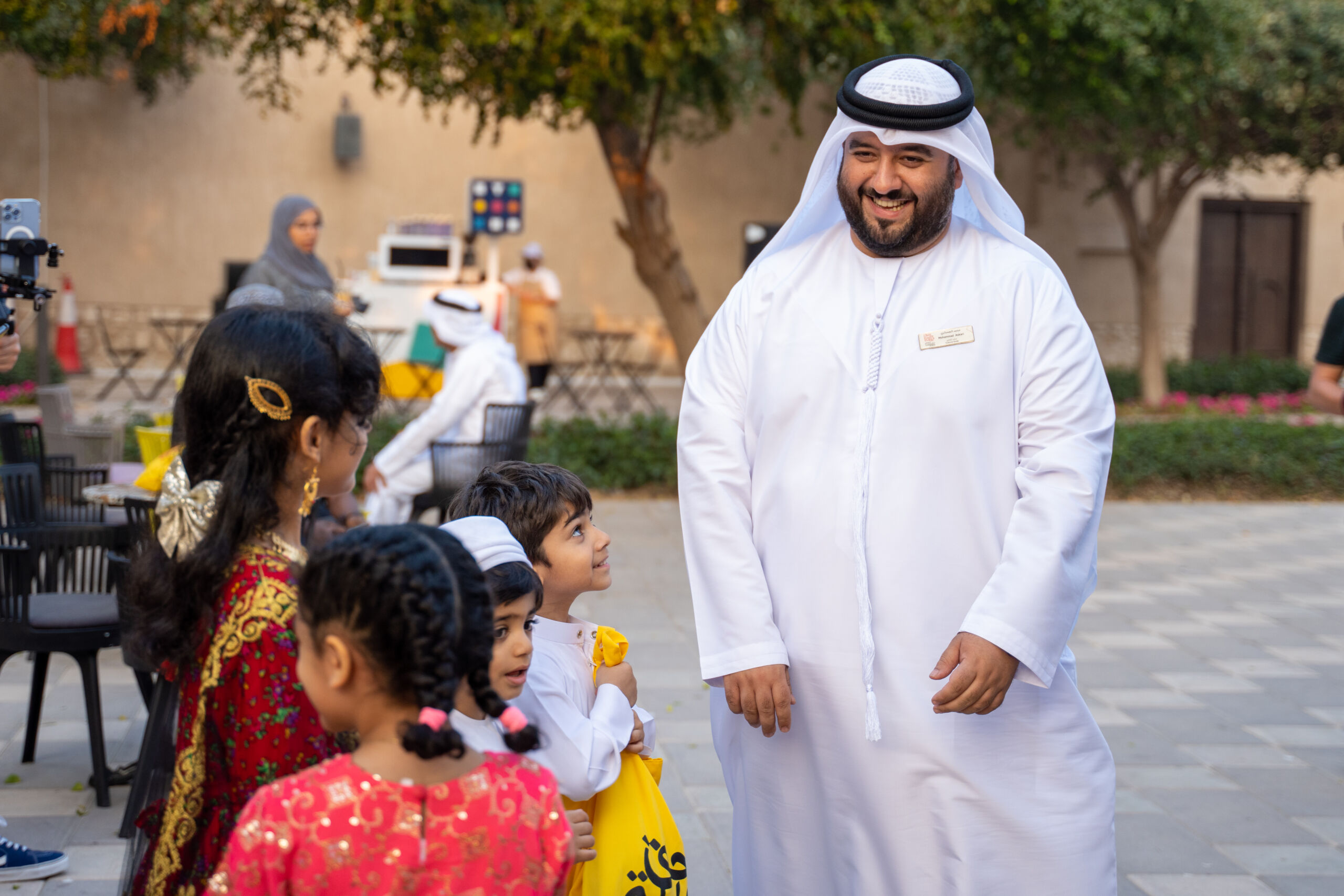 Image of Emirati man welcoming children collecting sweets for Hag Al Leila at Al Shindagha Museum