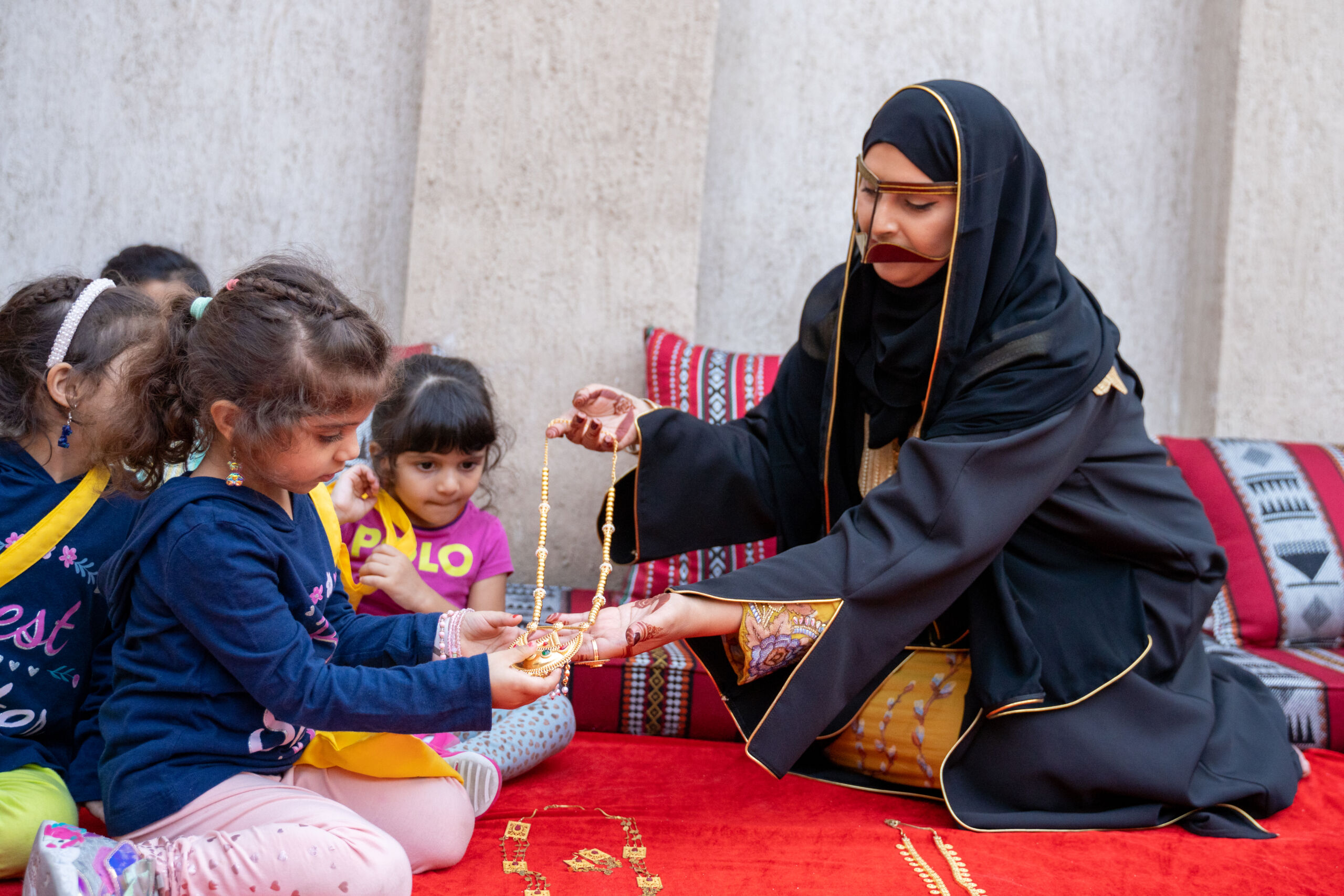 Image of Emirati woman instructing children about Hag Al Leila at Al Shindagha Museum